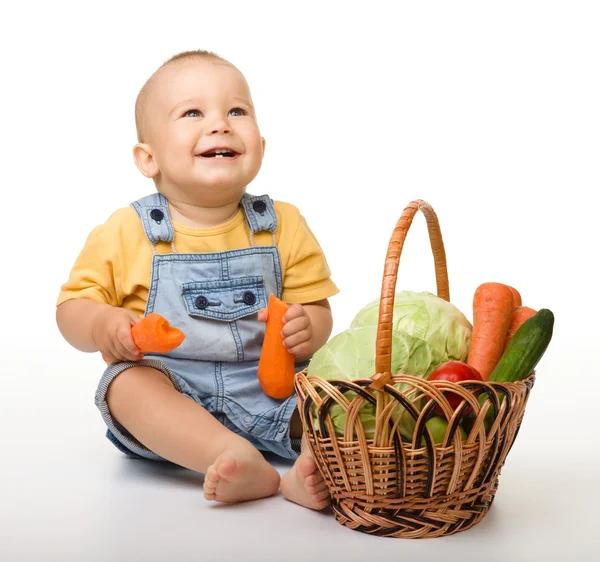Schattige kleine jongen met mand vol van groenten — Stockfoto