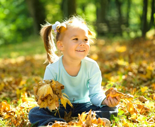 Niña está jugando en el parque de otoño —  Fotos de Stock