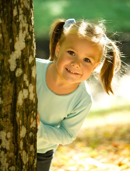 Klein meisje speelt in herfst park — Stockfoto