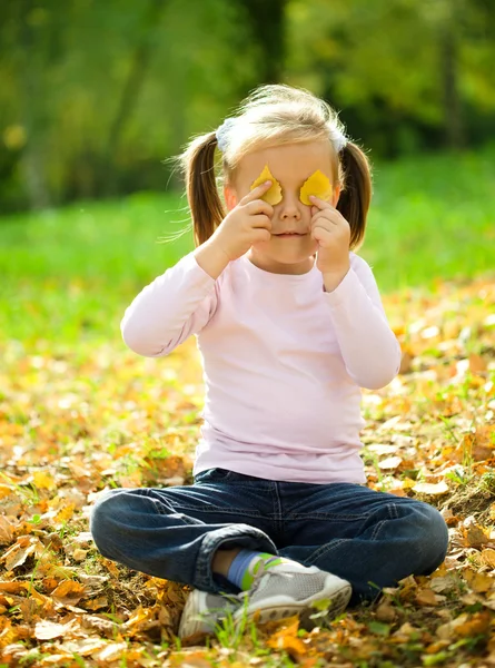 Niña está jugando en el parque de otoño — Foto de Stock
