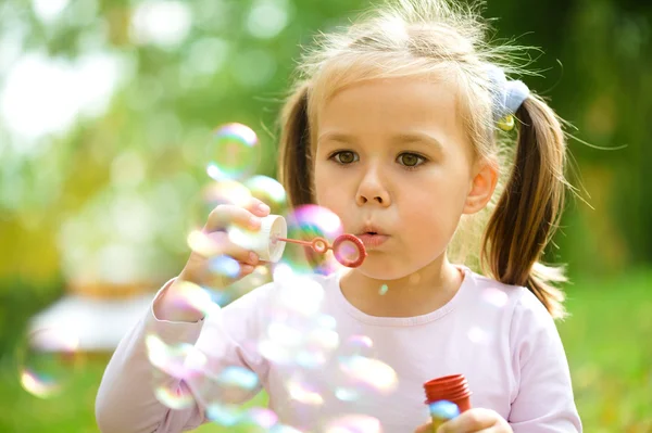 Klein meisje is een zeepbellen blazen — Stockfoto