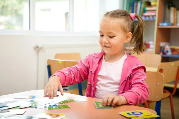 Nettes kleines Mädchen spielt mit Bildungskarten — Stockfoto