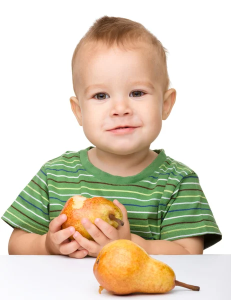 Söt liten pojke äter päron — Stockfoto