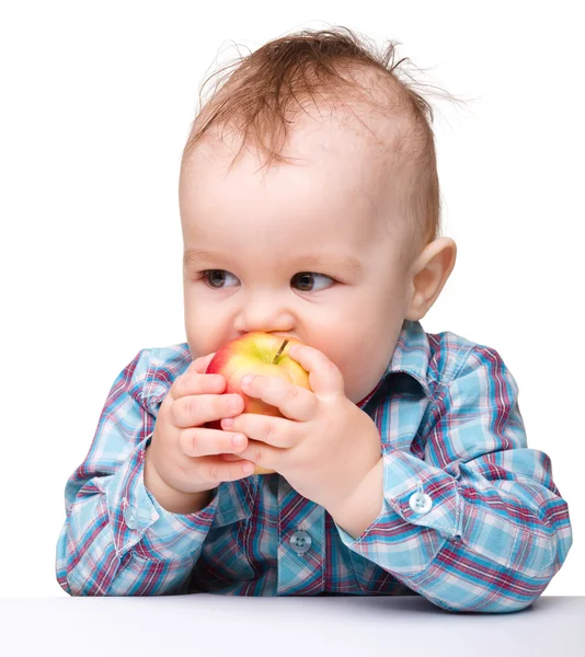 Маленький ребенок ест красное яблоко — стоковое фото