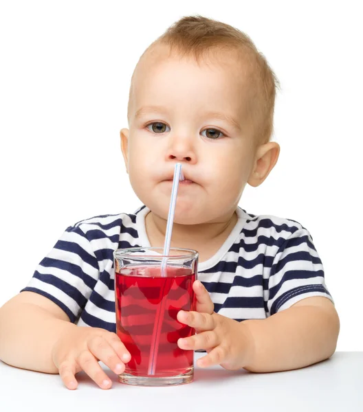 Schattige kleine jongen is rood sap drinken — Stockfoto