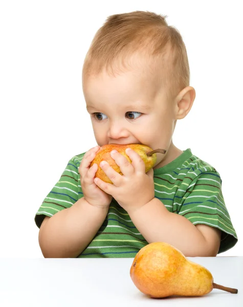 Cute little boy is biting pear — Stock Photo, Image