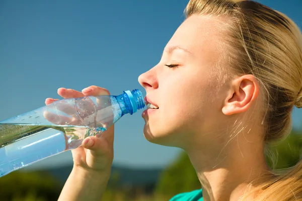 Молодая женщина пьет воду на открытом воздухе — стоковое фото