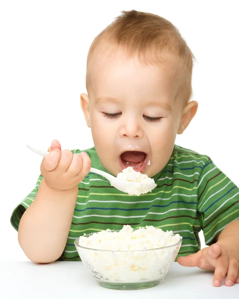 Μικρό αγόρι τρώει τυρί cottage χρησιμοποιώντας κουτάλι — Φωτογραφία Αρχείου