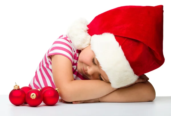 Cute little girl is sleeping wearing santa hat — Stock Photo, Image