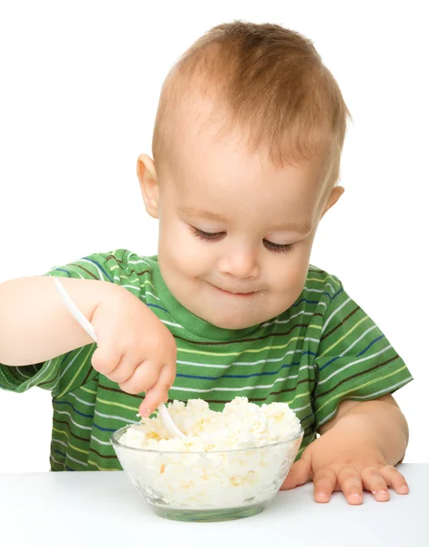 Liten pojke äter keso med sked — Stockfoto