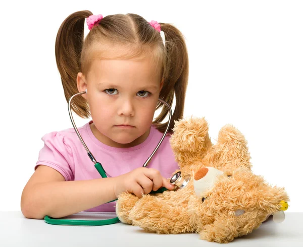 Little girl is playing with her teddy bear — Stockfoto