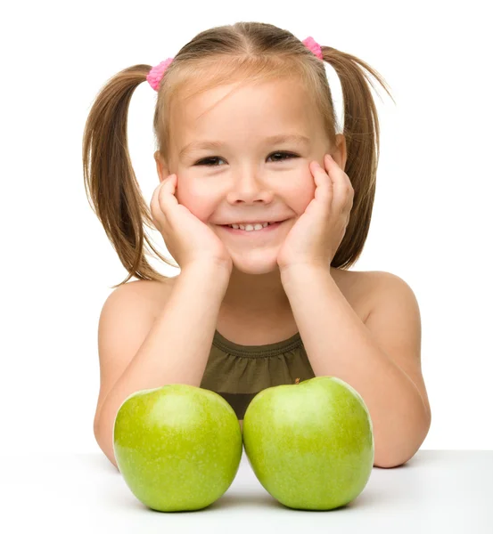 Liten flicka med två gröna äpplen — Stockfoto