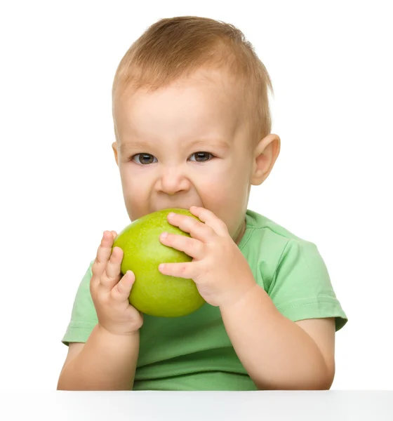 Little child is eating green apple — Stock Photo, Image