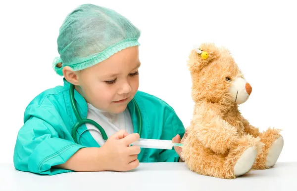 Маленькая девочка играет в доктора со шприцем — стоковое фото