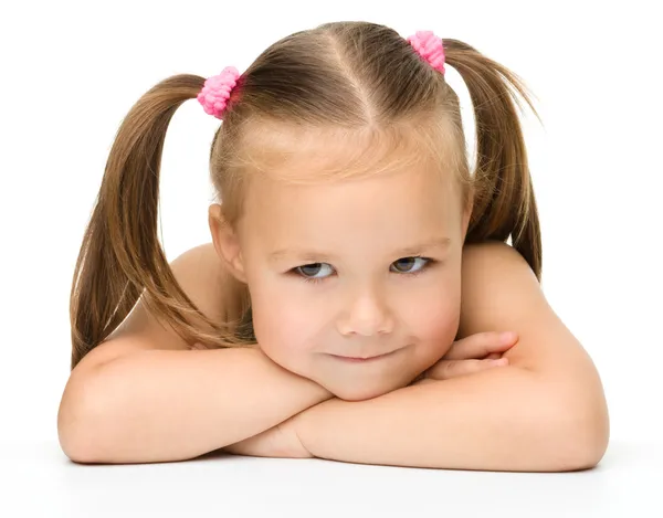 Cute little girl is sitting at the table Stock Photo