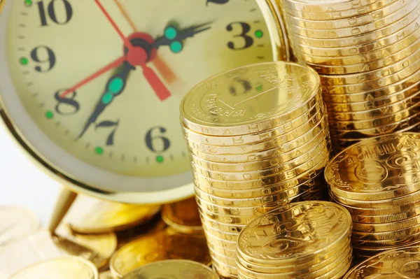 El tiempo es dinero - marcación del reloj y monedas de oro —  Fotos de Stock