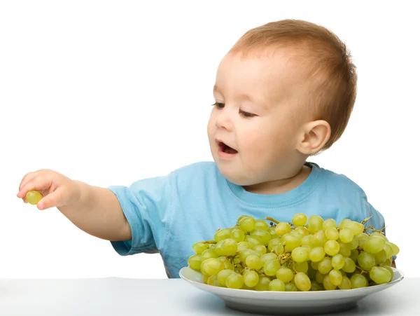 Menino está comendo uvas — Fotografia de Stock