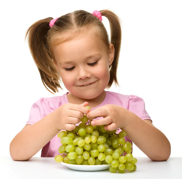 La bambina sta mangiando uva. — Foto Stock
