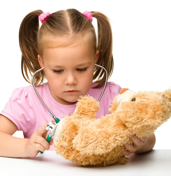 Little girl is playing with her teddy bear — Stok fotoğraf