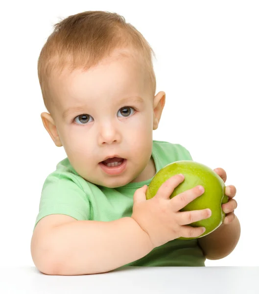 Pequeño niño está comiendo manzana verde —  Fotos de Stock