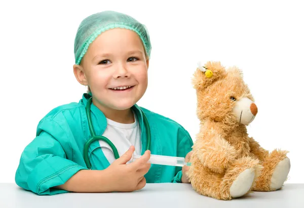 Маленькая девочка играет в доктора со шприцем — стоковое фото