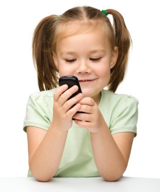 sevimli küçük kız cep telefonu ile oynuyor