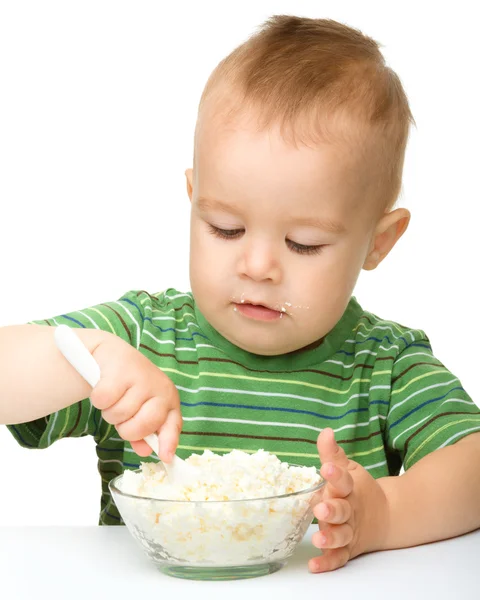 Little boy is eating cottage cheese using spoon — Stok fotoğraf