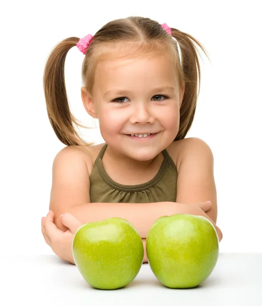 Маленькая девочка с двумя зелеными яблоками — стоковое фото
