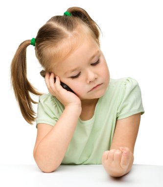 Cute little girl is talking on a cell phone clipart