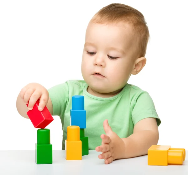 Niño juega con ladrillos de construcción — Foto de Stock