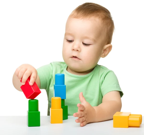 Kleine jongen speelt met bakstenen gebouw — Stockfoto