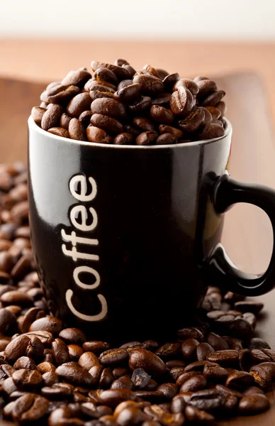 Kaffeebohnen und ein Kaffeebecher — Stockfoto