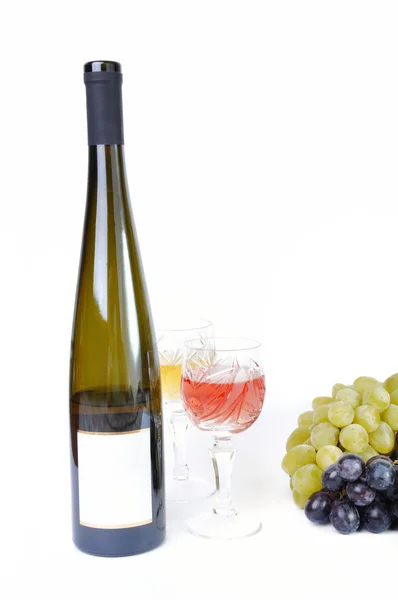 Láhev vína se sklenkami vína a hroznů izolován v bílém — Stock fotografie