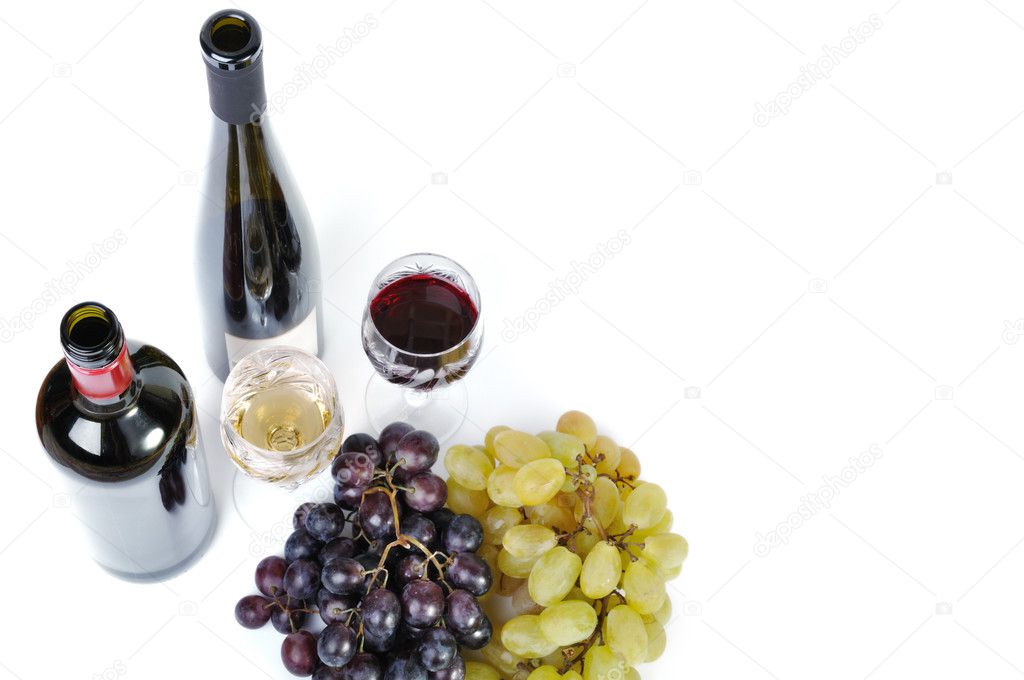 Two bottles of wine with two glasses of wine and grapes isolated in white