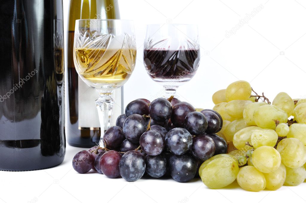 Two bottles of wine with two glasses of wine and grapes isolated in white