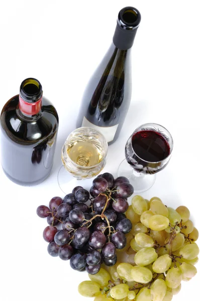 Duas garrafas de vinho com dois copos de vinho e uvas isoladas em branco — Fotografia de Stock