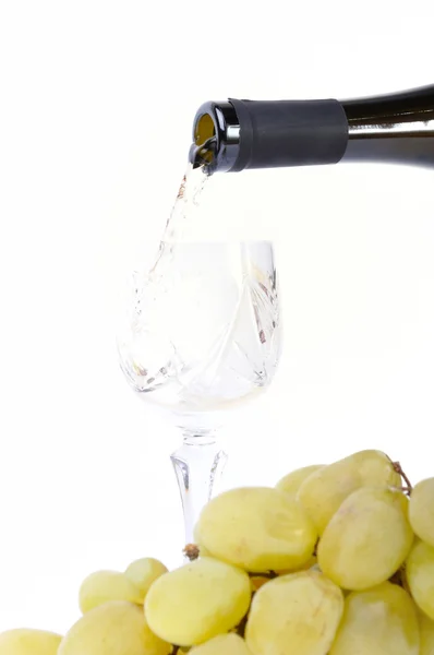 Λευκό κρασί που ρίχνει στο Κύπελλο και σταφύλια απομονωθεί σε λευκό — Φωτογραφία Αρχείου