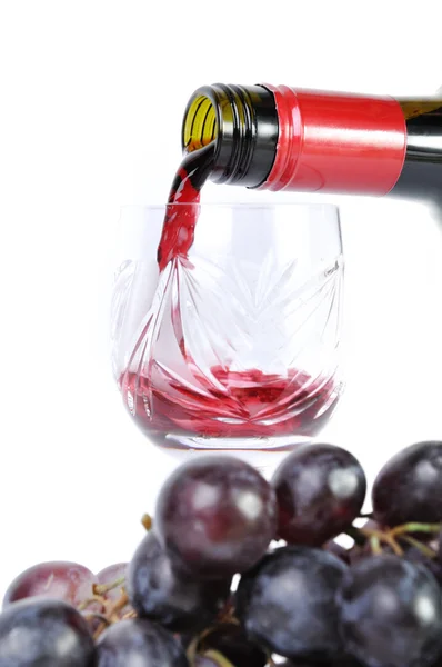 Vin rouge versé dans le gobelet et raisins isolés en blanc — Photo