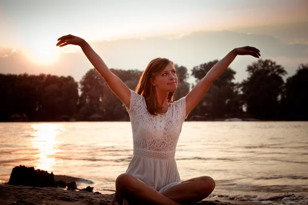 Щаслива жінка сидить біля річки — стокове фото