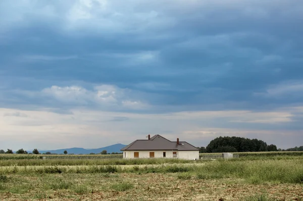 stock image Mountains and a house with dramatic sky