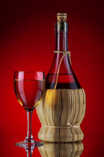 Fles en glas in het rood — Stockfoto