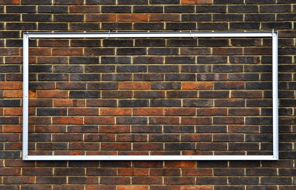 Metal frame on a brick wall — Stock Photo, Image