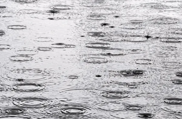 Chuva na superfície da água — Fotografia de Stock