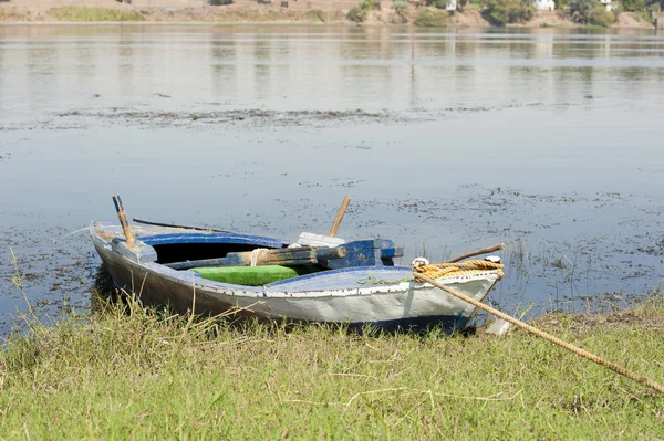 Nehir kıyısında eski kürek tekne demirleyen — Stok fotoğraf