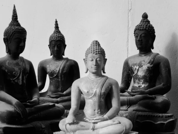 Un Buddha di pietra bianca e tre neri — Foto Stock