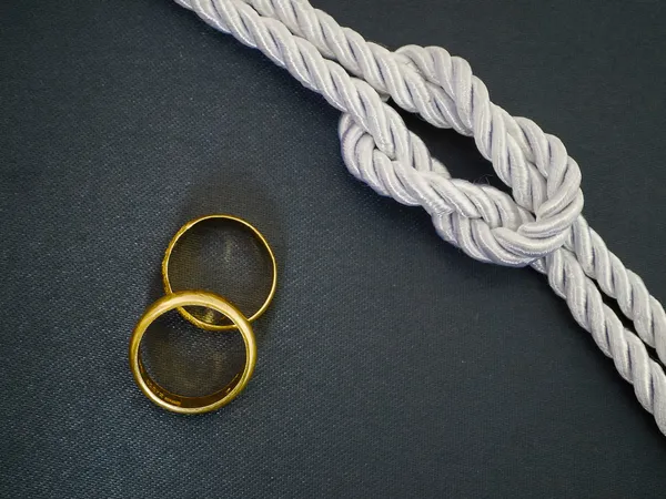 Silver Rope tie a knot and Two gold ring — Stock Photo, Image