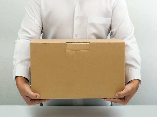 Homem carrega caixa de papel marrom — Fotografia de Stock