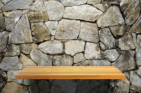 Wood shelf on stone wall — Stock fotografie