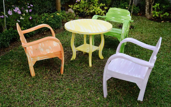 Tre trä stolar med armstöd och gula runda bordet — Stockfoto