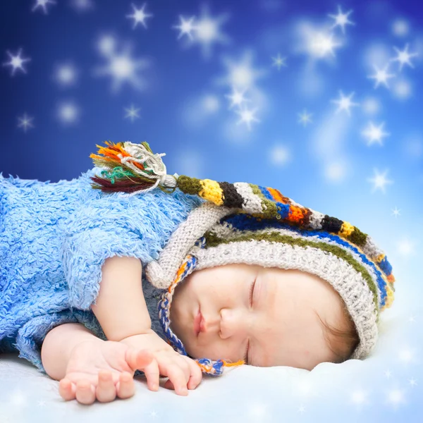 Bebé durmiendo en lindo sombrero. Fondo mágico cielo nocturno . Fotos de stock libres de derechos